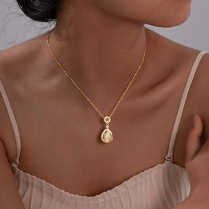 Détail du pendentif goutte en or 18 carats avec pierre poire sur collier porté