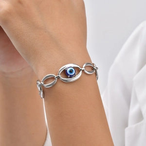 Detail of silver chain bracelet with evil eye pendant on a woman's wrist