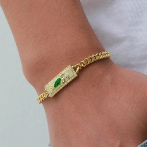 Detailed shot of gold Cuban chain bracelet with San Judas Tadeo medallion and green enamel