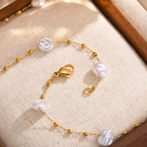 Detailed shot of gold-plated stainless steel chain with baroque pearls and lobster clasp