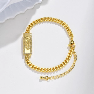 Macro view of gold Cuban link bracelet with Virgin of Guadalupe charm and crystals