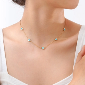 Collana d'oro in acciaio inossidabile con cinque cuori malocchio su una modella