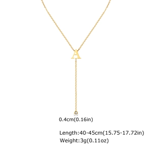 Detail showing golden necklace with letter A pendant and white zircon tassel charms