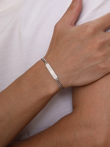 Gros plan d'un bracelet d'identité pour homme en acier inoxydable avec plaque polie au poignet