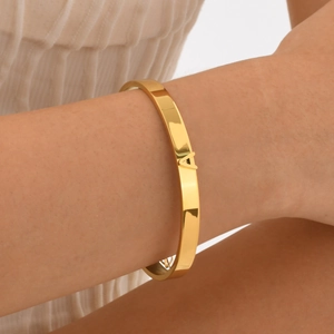 Bracelet jonc ouvert en acier inoxydable doré avec lettre A porté par un mannequin