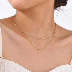 Close-up of double-layer gold chain necklace featuring a white zircon water drop pendant