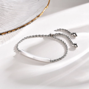 Vue détaillée du bracelet à barre courbée polie avec chaîne torsadée et fermoir réglable