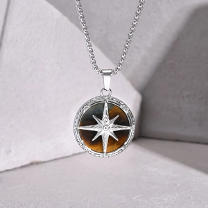 Macro detail of men's stainless steel compass necklace with natural brown tiger eye stone