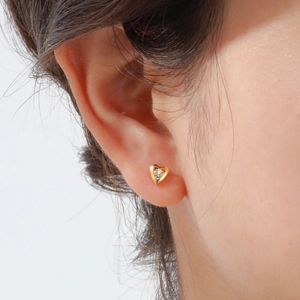 Orecchino a perno a cuore dorato con zircone, indossato sul lobo