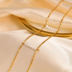Double-layered golden stainless steel choker featuring white faceted crystal beads detail