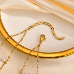 Double-layered gold stainless steel necklace featuring white crystal beads and lobster clasp