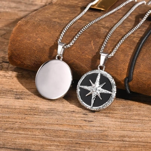 Detailed macro view of men's stainless steel compass star pendant with box chain on leather