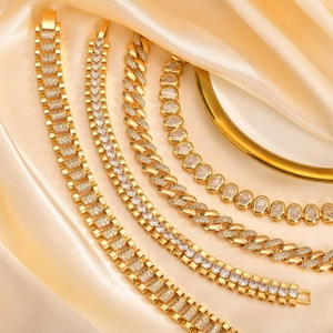 Close-up of gold plated link bracelets with sparkling cubic zirconia on silk fabric