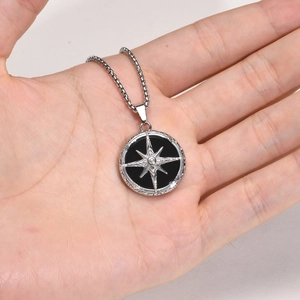 Detailed close-up of a men's stainless steel necklace with star and black stone pendant