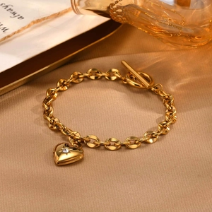 Dettaglio del ciondolo a cuore dorato con zircone e chiusura a levetta OT sicura