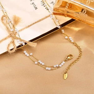 Détail du collier de perles double épaisseur doré avec étiquette K18 sur satin