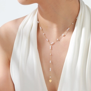 Elegant gold Y-shaped necklace with white pearls and heart pendant on model