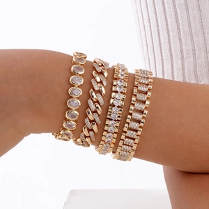 Set of four gold-plated chain bracelets with sparkling cubic zirconia on a female wrist