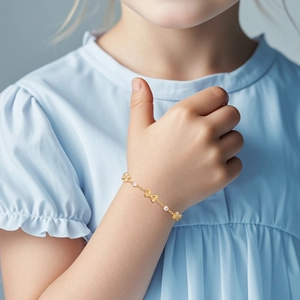 Detail of children's gold butterfly bracelet with zircon accents on a wrist