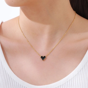 Minimalistische goldene Edelstahl-Herz-Halskette mit schwarzem Emaille-Inlay an einem Model