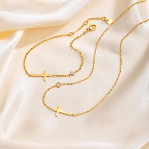 Detailsicht der goldenen Kreuzkette mit weißem Zirkon auf Seidenstoffhintergrund