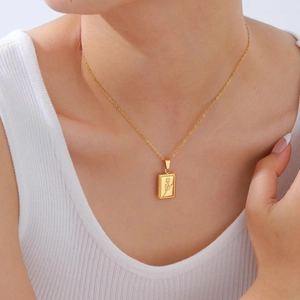 Gold stainless steel rectangle pendant necklace with engraved tulip on model