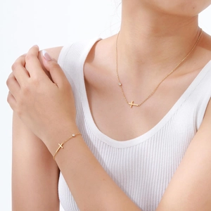 Goldenes Kreuz-Halsketten- und Armband-Set mit weißen Zirkonia-Steinen am Model