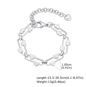 Détail macro du bracelet à breloques cœur en acier inoxydable argenté avec fermoir mousqueton