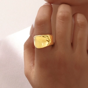 Bague large irrégulière en acier inoxydable doré avec texture lave portée par un mannequin