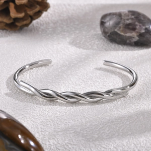 Detailed macro view of the twisted texture on a polished silver stainless steel cuff bracelet