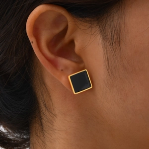 Minimalist square geometric gold stud earrings with black enamel inlay on female model