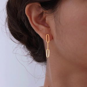 Minimalist gold-plated double paperclip chain earrings worn by a female model