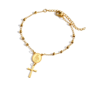 Détail d'un bracelet en chaîne à billes dorée avec médaille de la Vierge et croix pendante