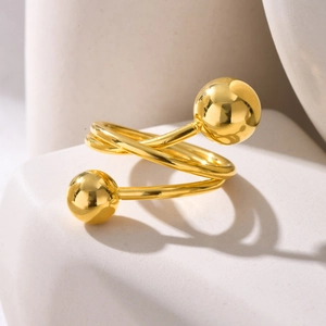 Macro detail of golden spiral open ring with polished beads on white geometric base