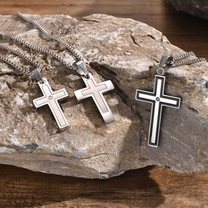 Vue détaillée de trois colliers à pendentif croix en acier inoxydable sur une roche