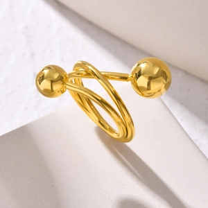 Macro detail of a gold three-layer crossover ring featuring polished spherical accents