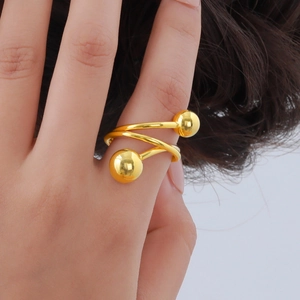 Macro shot of gold double-layer spiral ring with polished spherical ends on model finger