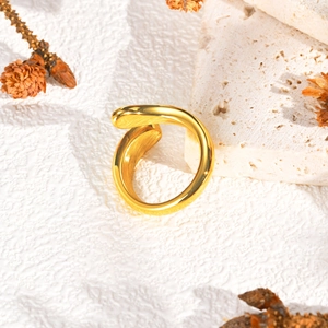 Vue détaillée d'une bague dorée à triple couche ondulée sur un décor en pierre