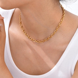 Gros plan d'un collier chaîne dorée à texture torsadée sur un mannequin féminin