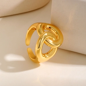Detailed view of an adjustable gold infinity ring on a beige geometric display stone