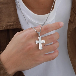 Gros plan d'un collier avec pendentif croix argentée double couche pour hommes