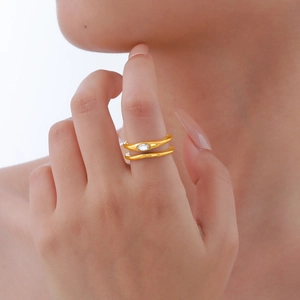 Detail of gold wrap ring with inlaid oval zircon on a model's finger for an elegant look