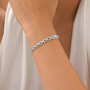 Close-up of a minimalist silver rectangular link chain bracelet worn on a female wrist