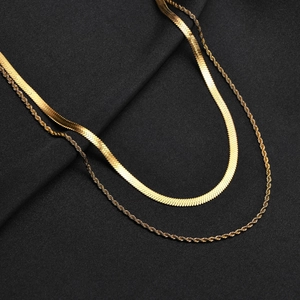 Détail macro du collier double rang doré avec chaîne serpent et chaîne torsadée
