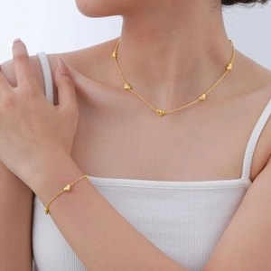 Ensemble collier et bracelet cœur en acier inoxydable doré avec zircons sur mannequin
