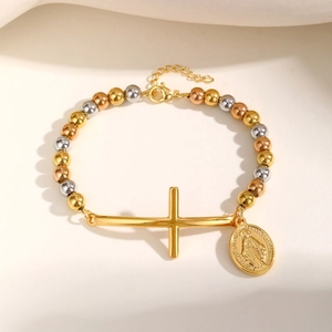 Dettaglio del bracciale a sfere tricolore con croce dorata e ciondolo religioso