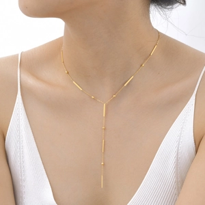 Collier en Y doré avec barres carrées porté par un mannequin pour un look chic