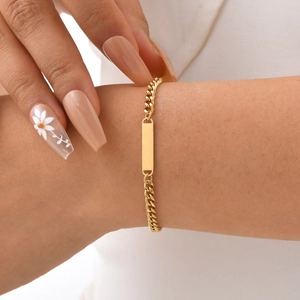 Détail d'un bracelet gourmette doré avec plaque rectangulaire polie personnalisable
