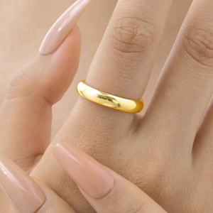 Polished 14K gold stainless steel minimalist domed ring worn on a female hand