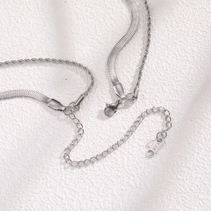 Vue macro d'un collier double épaisseur en acier inoxydable avec pendentif gravé K18